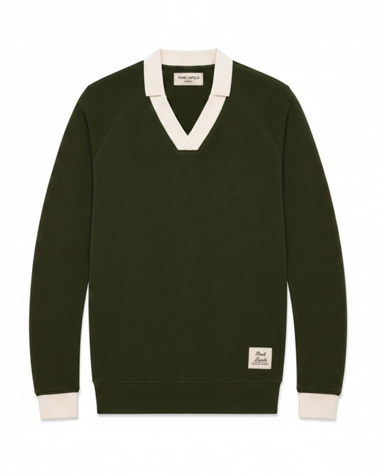A dark olive green long-sleeve V-neck sweater with contrasting cream ribbed trim at the collar, cuffs, and hem, featuring a small brand patch on the lower left hem.